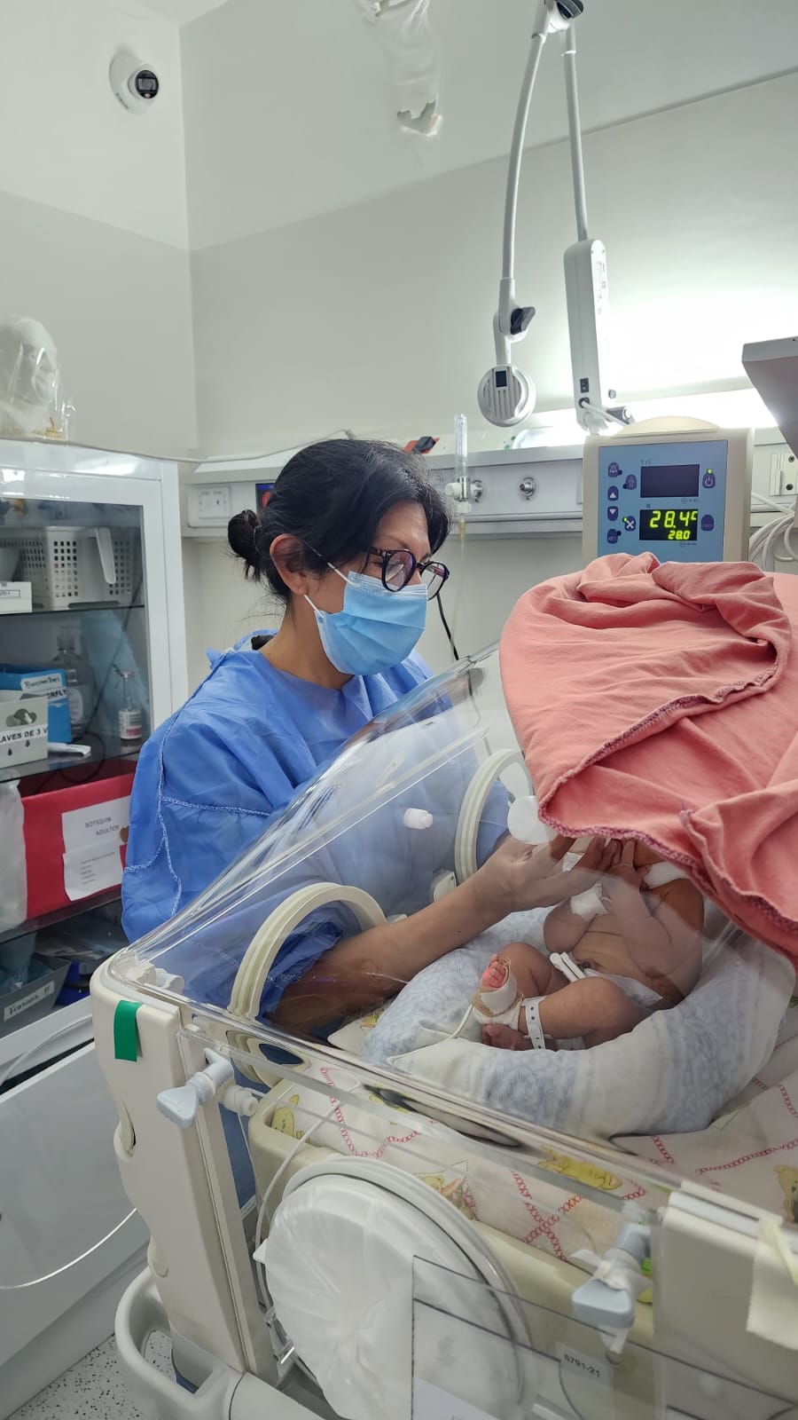 Enfermera cuidando a un bebé en una incubadora