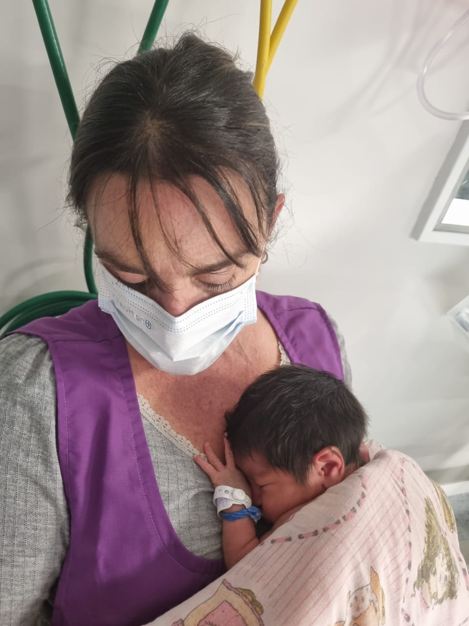 Voluntaria de la fundación abrazando a un bebé prematuro